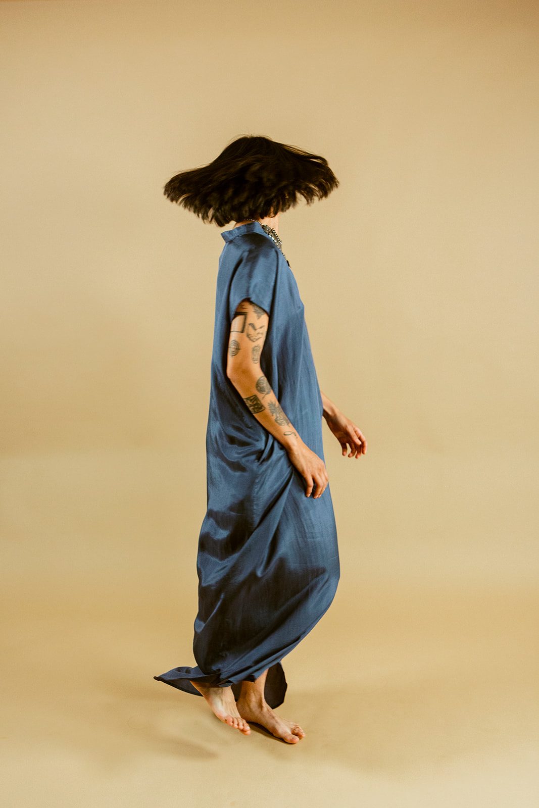 Slate-blue silk caught mid-motion in the studio
